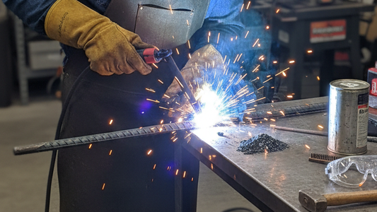 a man welding the rebar pin to fix the fracture in the workshop